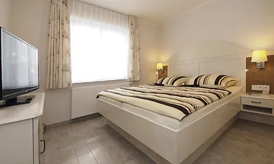 Schlafzimmer mit Doppelbett und 2. Flachbildfernseher