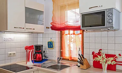 Küche mit Herd, Kaffeemaschine und Mikrowelle.