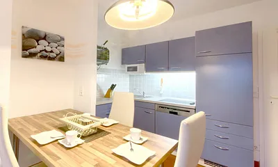 Der große Esstisch und die Küche mit Geschirrspüler