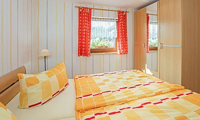 Schlafbereich mit Doppelbett und Schrank.