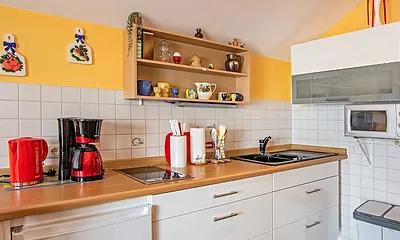 Küche mit Kaffeemaschine, Wasserkocher und Toaster.