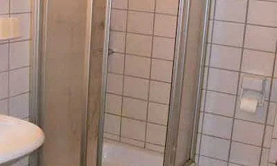 Badezimmer mit Dusche, Waschbecken, WC und Waschmaschine