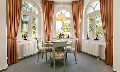 Im großen Erker des Wohnzimmers ist ein komfortabler Eßplatz eingerichtet.
