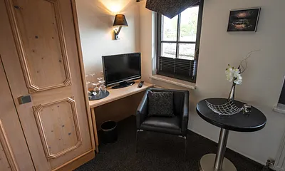 Detailansicht Einzelzimmer, hier Sitzgruppe, Minibar, Kleiderschrank