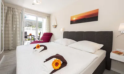 Schlafzimmer mit Doppelbett und Relaxsessel