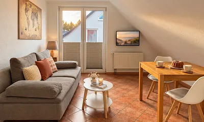 Wohnzimmer mit Balkon und Flachbild-TV.