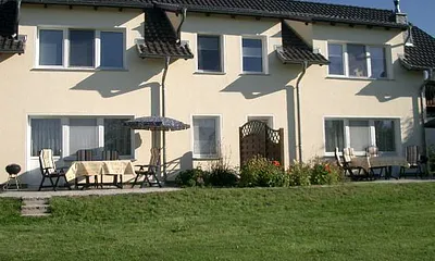 Blick vom Garten auf die Terrasse mit Grill