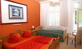 Schlafzimmer 1 mit einem Doppelbett  und einem Einzelbett ,Kleiderschrank, TV und Ausgang zum Balkon