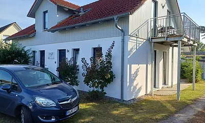 Vorderansicht mit Parkplatz und Balkon