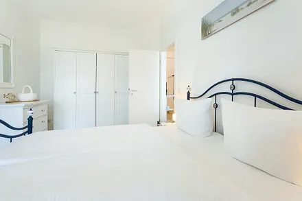 Schlafzimmer mit Doppelbett und Kleiderschrank