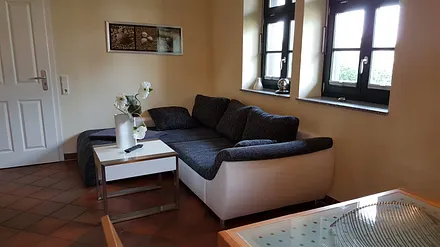 Detailansicht, bequeme Sitzcouch mit Ottomane in unseren Dreiraumwohnungen 