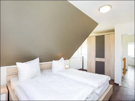 Schlafzimmer mit Doppelbett und Kleiderschrank