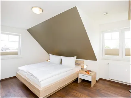 Schlafzimmer mit Doppelbett und Kleiderschrank