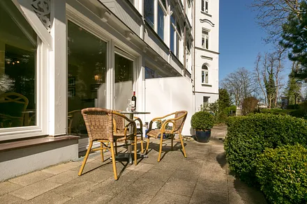 Ihre möblierte Terrasse schaut nach Osten. Rechts im Bildhintergrund sehen Sie die Strandpromenade.