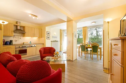 Blick auf die Küchenzeile mit Backofen und Geschirrspüler. Auf der Couch kann aufgebettet werden.