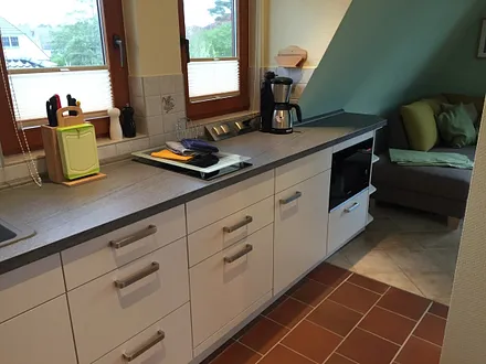 Küchenzeile mit Herd, Kühlschrank, Mikrowelle und Geschirrspüler