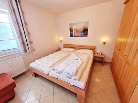 Schlafzimmer mit Schrank, Plissee und Fliegengitter, Smart TV für Onlinedienste, mit dem Netflix, Magenta TV, Amazon Prime, usw. verfügbar