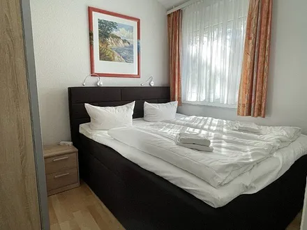 Schlafzimmer mit Boxspringbett und Schiebetürenschrank