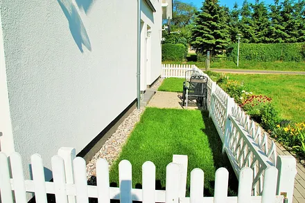 Eingezäunter Vorgarten mit kleiner Terrasse