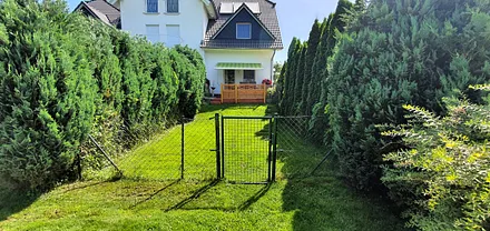 Blick auf den umzäunten Rasen mit Terrasse