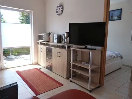 Mikrowelle, Radio-CD, Kaffeemaschine; LED HD TV, rechts das Schlafzimmer