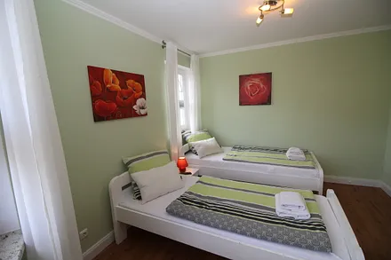 Grünes Schlafzimmer mit 2 Doppelbetten