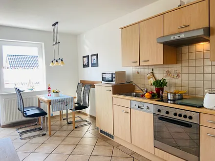 Essecke mit komplett ausgestatteter Küchenzeile (z.B. Backofen, Geschirrspüler, Mikrowelle, Kühlschrank mit Gefrierfach usw.)