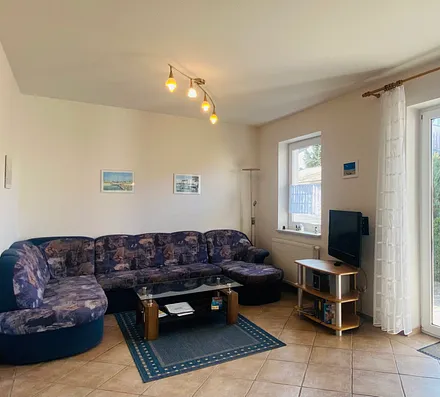 Essecke mit komplett ausgestatteter Küchenzeile (z.B. Backofen, Geschirrspüler, Mikrowelle, Kühlschrank mit Gefrierfach, Geschirr usw.) und Blick auf die Terrasse