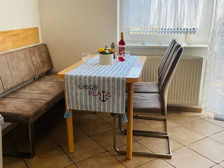 Essecke mit komplett ausgestatteter Küchenzeile (z.B. Backofen, Geschirrspüler, Mikrowelle, Kühlschrank mit Gefrierfach, Geschirr usw.)