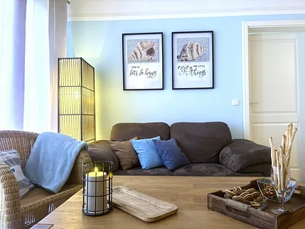 Wohnbereich im dezent maritimen Stil, der die Farben des Strandes und des Meeres wiederspiegelt, für eine erholsame Urlaubsatmosphäre