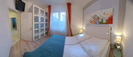 Schlafzimmer mit einem  Doppelbett, Kleiderschrank und einem TV