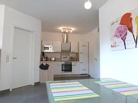 Blick vom Esstisch zur voll ausgestatteten Küchenzeile