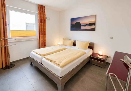 Schlafzimmer mit Doppelbett und zweitem Fernseher