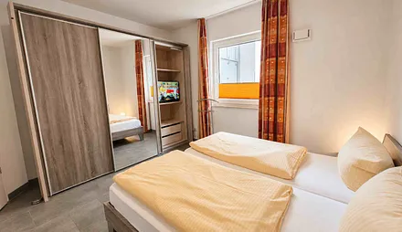 Schlafzimmer mit Doppelbett und zweitem Fernseher