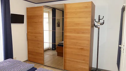 Im Schlafzimmer finden Sie außerdem einen LCD-Fernseher und einen sehr geräumigen Kleiderschrank mit Ganzkörperspiegel, Zugang zum Innenhof über Kipptür