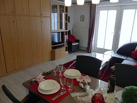 Schrankwand im Wohnbereich mit Schrankbett zur Schlafgelegenheit für die 3. und 4. Person, TV, DVD-Player, Soundbar, Audio-Anlage, Infomappe, Gebrauchsanleitungen, Spiele, Bücher, uvm.