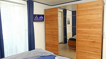 Im Schlafzimmer finden Sie außerdem einen LCD-Fernseher und einen sehr geräumigen Kleiderschrank mit Ganzkörperspiegel, Zugang zum Innenhof über Kipptür