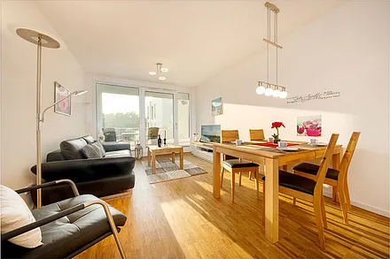 Der nach Süden ausgerichtete und komfortabel möblierte Balkon ist vom Wohnzimmer begehbar. An den Fenstern sind Sichtschutzplissees installiert.