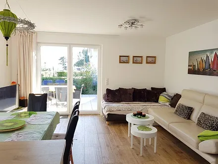 Ein breites, beiges Ledersofa in modernem Design sorgt für besten Sitzkomfort.