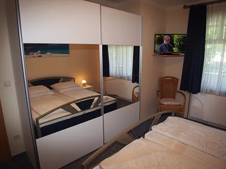 Schlafzimmer mit Spiegelschrank und TV-Gerät