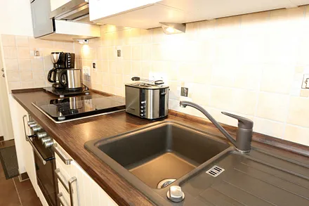 integrierte Küchenzeile mit Mikrowelle, Backofen, Ceranfeld, Spülmaschine, Kühlschrank mit Gefrierfach, Kaffeemaschine und anderen praktischen Hilfsutensilien