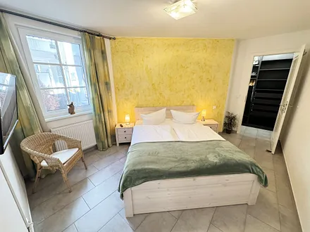 Schlafzimmer mit Doppelbett (1,60 m x 2,00 m), kleiner Flachbildschirm, Nachttischkonsolen, begehbarem Kleiderschrank und Insektenschutzgitter