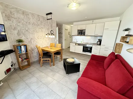 Wohnbereich mit einer Essecke, gemütlicher Couch (Aufbettung für 3./4. Person 1,60 m x 2,00 m), Smart-TV,Blu-Ray-Player und Musikanlage mit DAB Radio