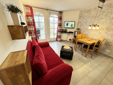 Wohnbereich mit einer Essecke, gemütlicher Couch (Aufbettung für 3./4. Person 1,60 m x 2,00 m), Smart-TV, Blu-Ray-Player und Musikanlage mit DAB Radio