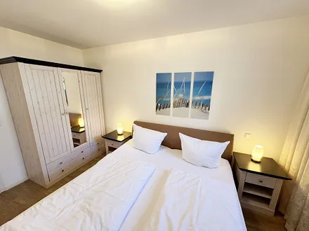 Schlafzimmer mit Doppelbett und Kleiderschrank