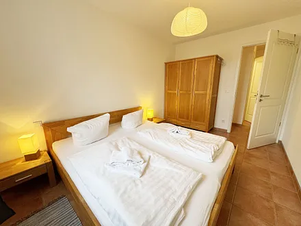 Schlafzimmer mit Doppelbett und Kleiderschrank