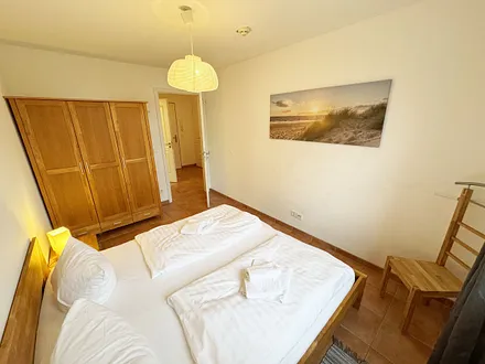 Schlafzimmer mit Doppelbett und Kleiderschrank