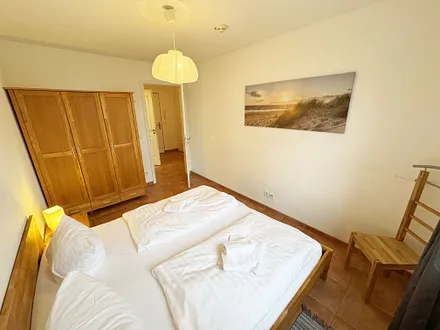Schlafzimmer mit Doppelbett und Kleiderschrank