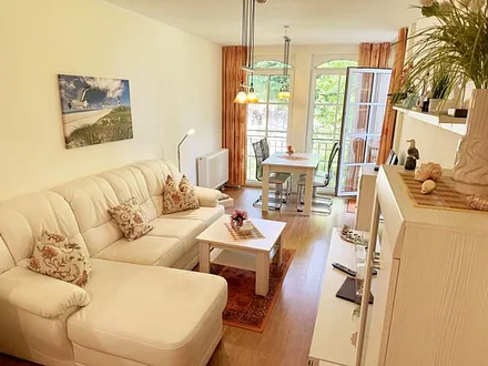 Wohnbereich mit gemütlicher Couch, Leselampe, Smart-TV, DVD-Player und Radio mit CD