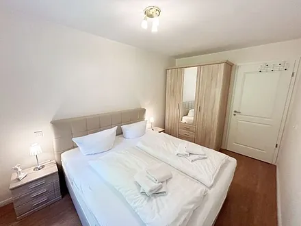 Schlafzimmer mit einem Boxspringbett (1,80 m x 2,00 m), Ablagefläche, Kleiderschrank und Insektenschutzgitter